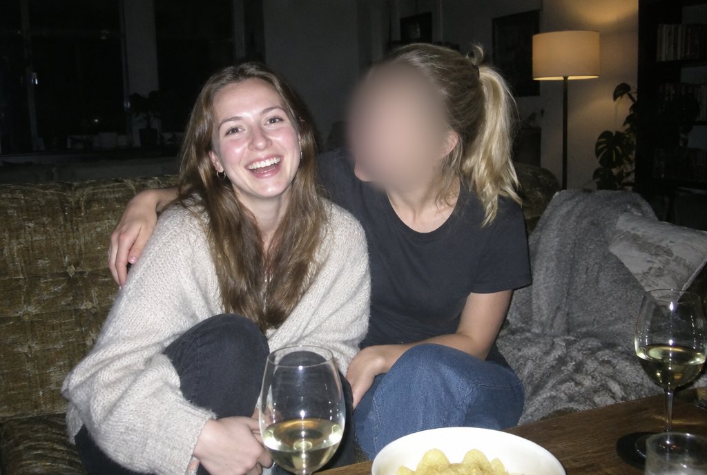 Sarah lachend mit einer Freundin auf dem Sofa