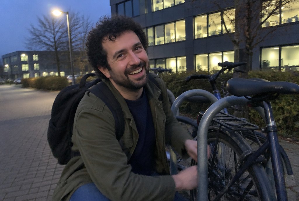 Lukas lacht beim Abschließen seines Fahrrads nach Feierabend